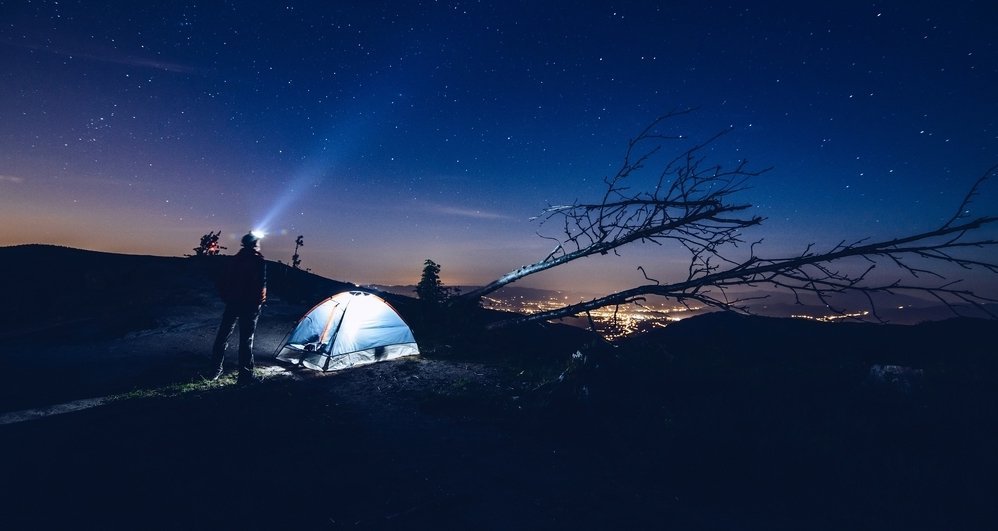 stan v lese ve tmě svícení čelovkou