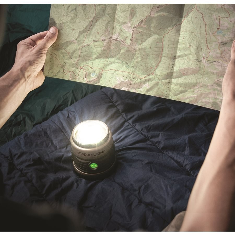 Lampa položená na spacáku u mapy